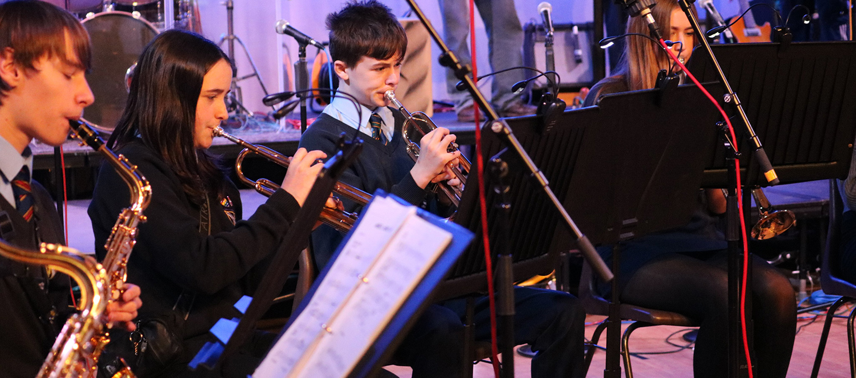 Kennet School music pupils playing brass instruments whilst performing in a school concert