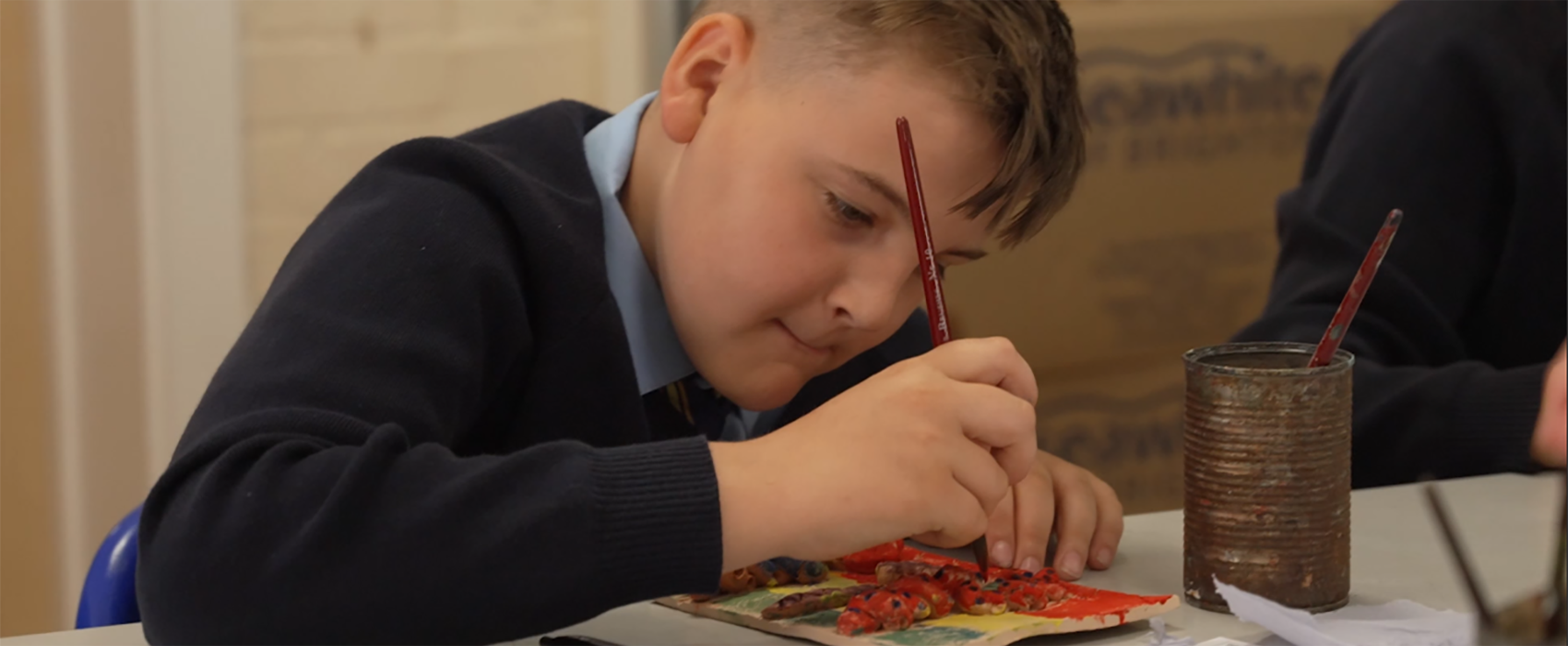 Pupil engaged in painting during art class