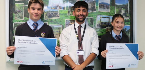 A teacher and a group of pupils smiling and proudly holding up the school's recent SSAT award.