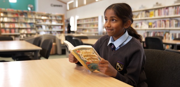 Year 7 pupil at Kennet School reading a book, reflecting the school’s successful literacy initiatives and growing enthusiasm for reading.