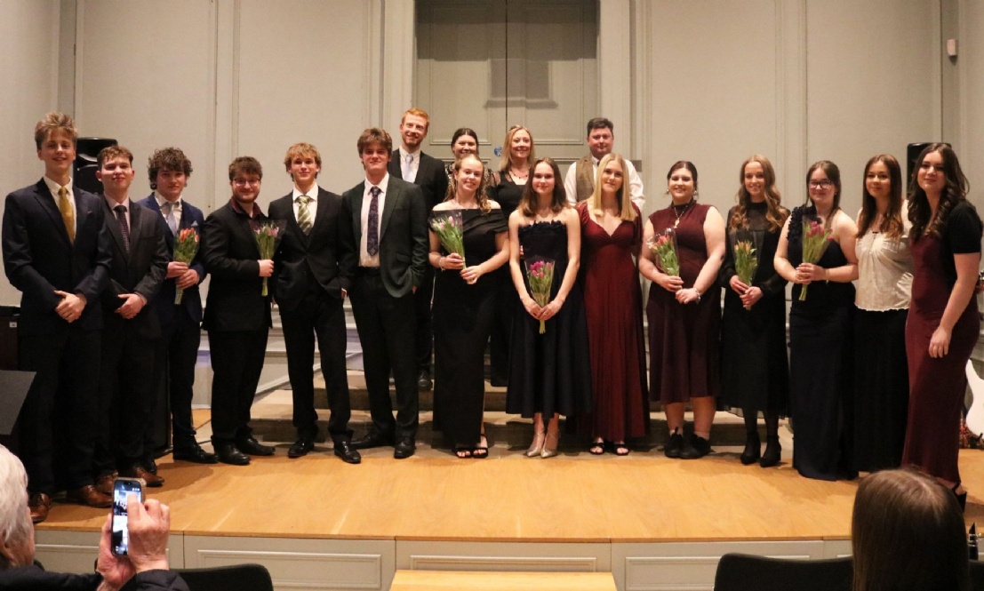 Year 13 students and Music teachers stood with flowers at the end of the Sixth Form Music Recital
