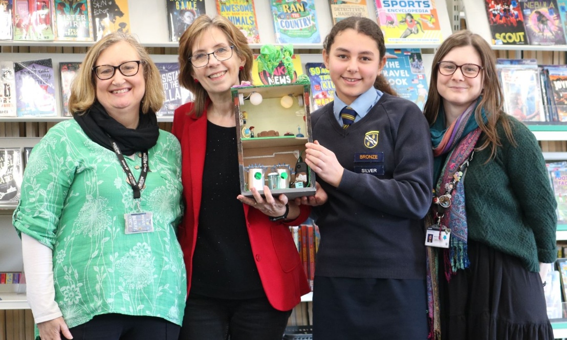 A group of people holding the winning prize for the Shared Reading Competition, announced at this year's BookFest