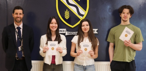 Students holding certificates and stood with Acting Headteacher